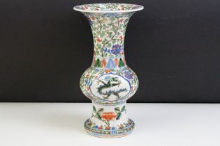 Chinese porcelain gu vase having blue underglaze detailing featuring a dragon with green, red and