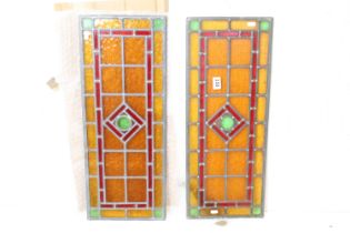 Pair of Art Deco leaded stained glass panels, each with a central green roundel bordered by a red