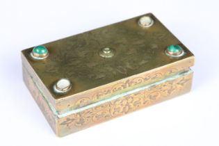 An antique brass vesta box with chased decoration and cabochon settings to lid, strkier to base