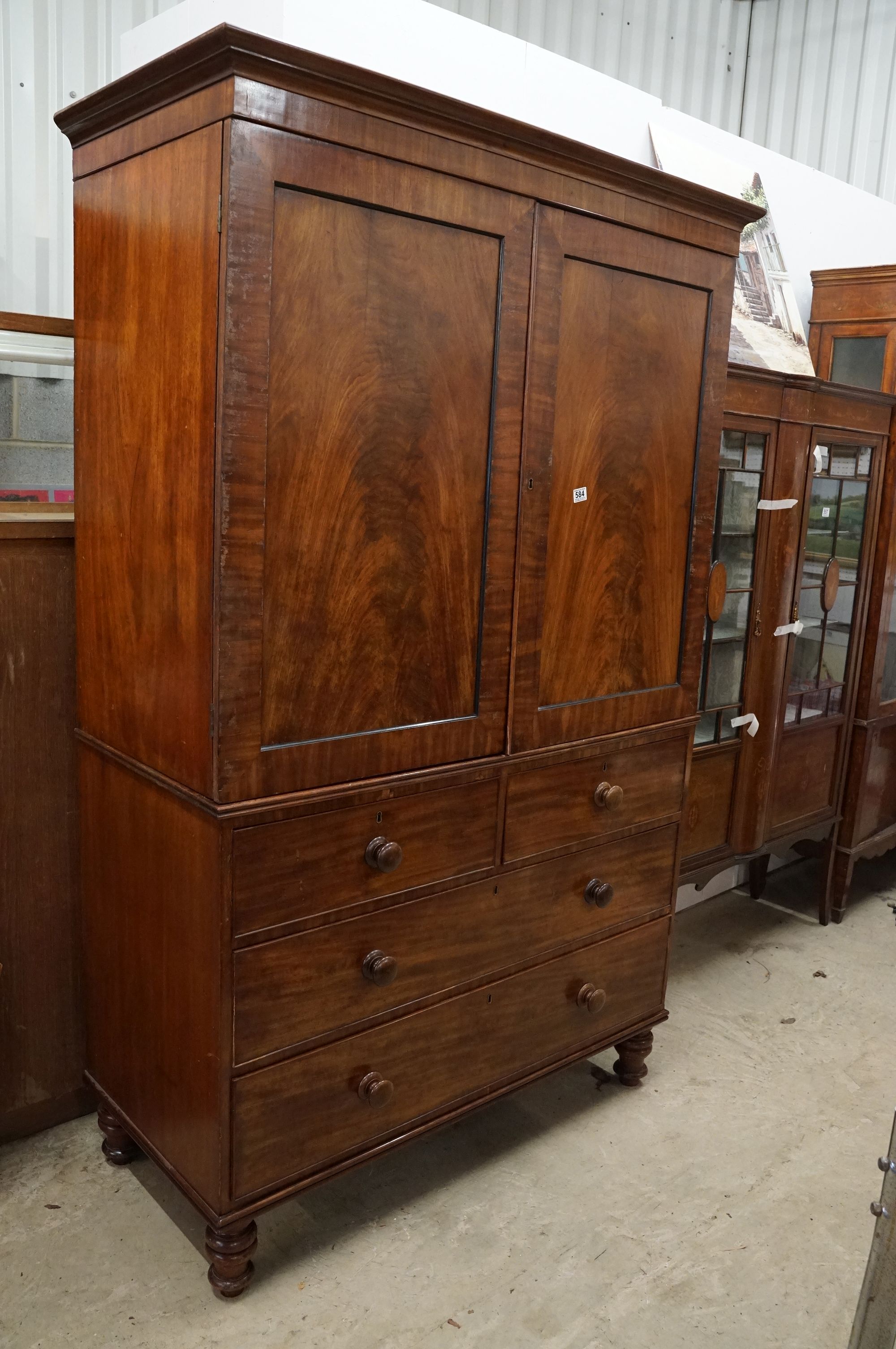 Early 19th century Mahogany Linen Press, the two panel doors opening to four tray slides, over two