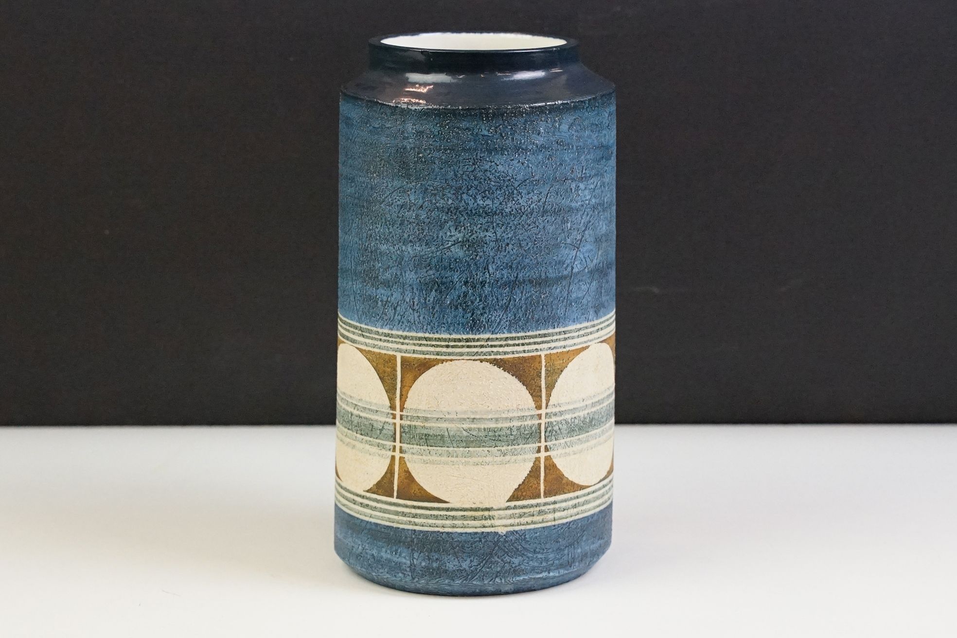 Mid Century Troika pottery vase of cylindrical form with circular pattern on a blue ground. Signed