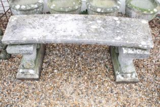 Reconstituted stone garden bench with curved seat raised upon lion supports (matched), approx