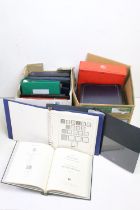 A collection of empty stamp albums and stock books contained within two boxes.