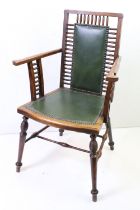 Arts and Crafts style Spindle Back Elbow Chair with studded green leather back and seat raised on