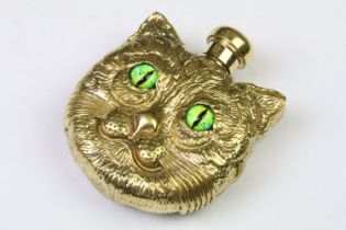 A decorative gold coloured scent bottle in the form of the Cheshire cat