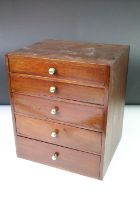 Mahogany desk top set of drawers having a bank of five drawers with brass knob handles.