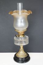 19th Century Victorian oil lamp having a round fluted brass base, faceted clear glass reservoir, and