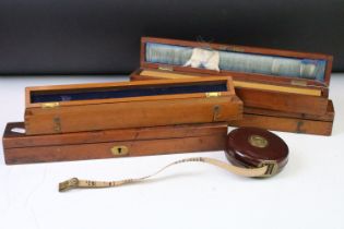 A collection of early to mid 20th century boxwood rulers together with wooden storage boxes to