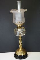 Late Victorian / early 20th Century oil lamp raised on a round black pedestal base, brass twist