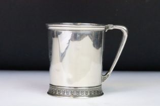 A christening cup with single handle, ornate decoration to the foot, marked English Sterling to