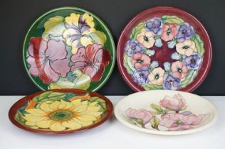 Four Moorcroft pottery plates, to include an early-to-mid 20th C Hibiscus pattern plate on green