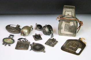 A collection of mainly Indian white metal amulets including an example set with a large turquoise