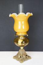 19th Century Victorian oil lamp having a cast brass base with moulded roses, amber glass reservoir