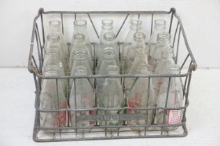 Collection of 20 glass milk bottles with dairy advertising, housed within a metal crate (approx 47cm