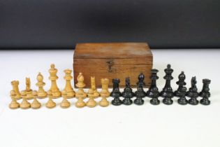 A set of early 20th century boxwood chess pieces within wooden box.