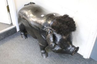 Ebonised Wooden Footstool in the form of a Pig with brush boot cleaner to top of head, 103cm long