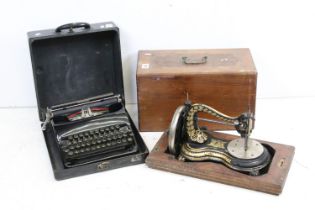 An early 20th century cast iron sewing machine within fitted wooden box together with a vintage