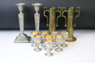 Set of eight white metal drinking vessels with cast grape & vine decoration and gilt interiors (