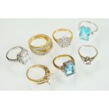 Seven stone set dress rings to include a tru gems white stone ring, cluster ring, two blue stone