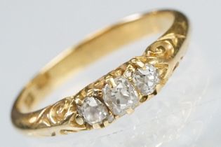 Early 20th Century 18ct gold and diamond three stone ring rectangular cut diamonds set to a scrolled