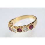 18ct gold, ruby and diamond seven stone ring. The ring being set with three round cut diamonds,