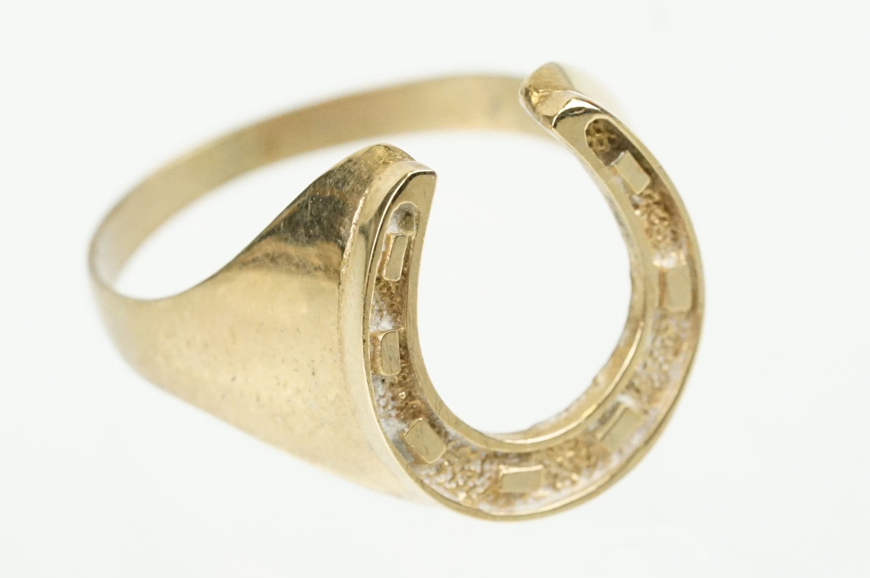 9ct gold horse shoe ring with moulded details. Hallmarked present but rubbed. Size S.5.