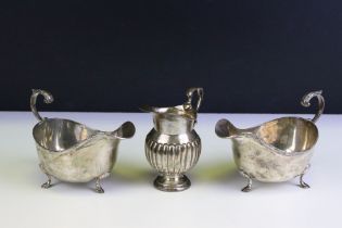 Three silver hallmarked jugs to include a pair of Walker and Hall gravy jugs with moulded rims (