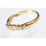 18ct gold and diamond five stone ring being bezel set with five graduating round cut diamonds. 750