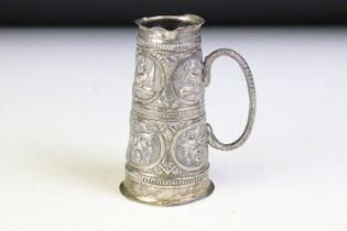 19th Century Indian silver white metal measure cup having repousse deities to the sides, of tapering