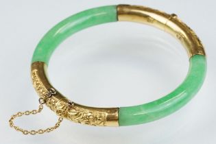 Chinese jade and gold hinged bangle bracelet. The bracelet of round form with gold hinge section and