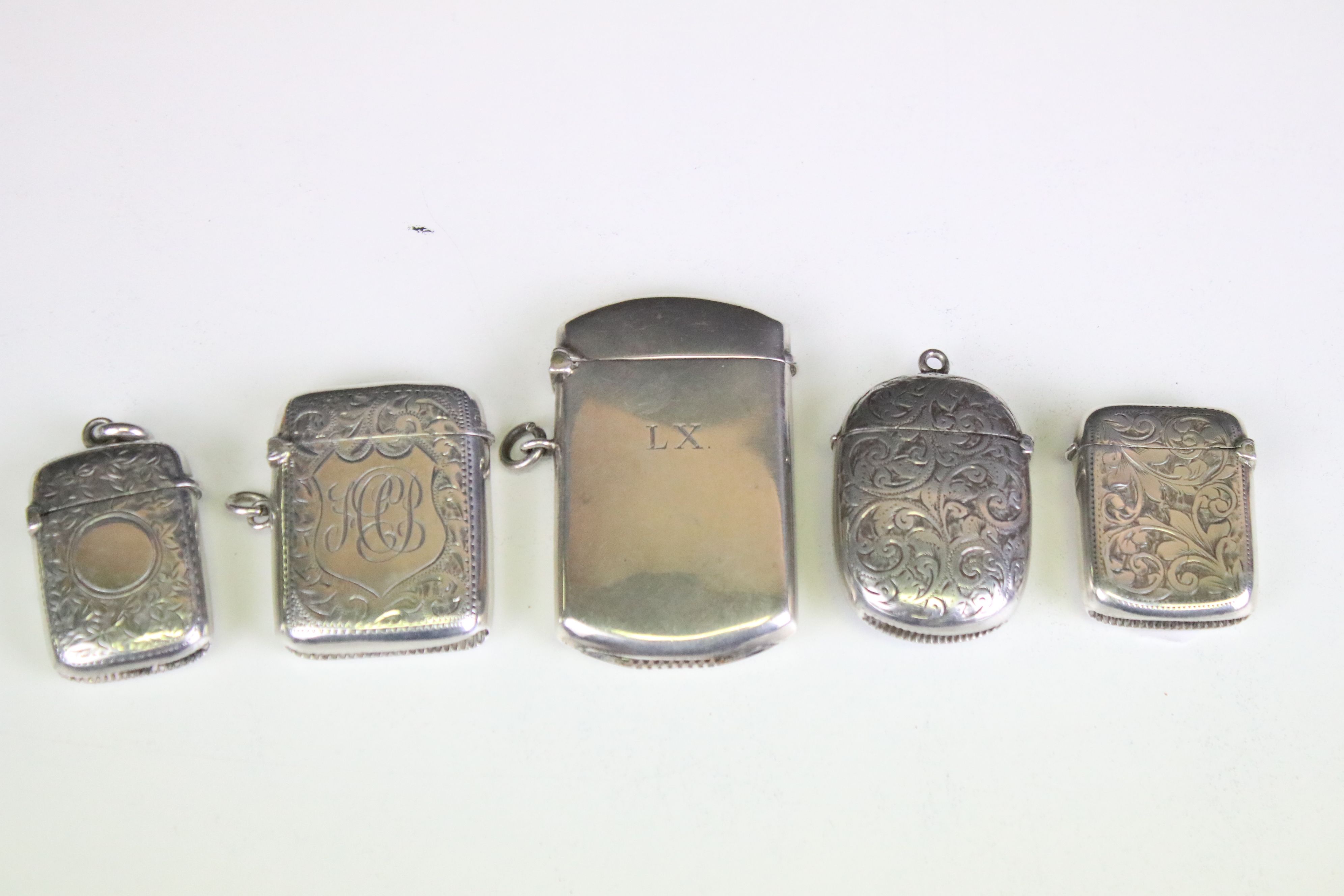 Group of five silver hallmarked vesta cases, featuring a 1920's vesta case of plain polish slim