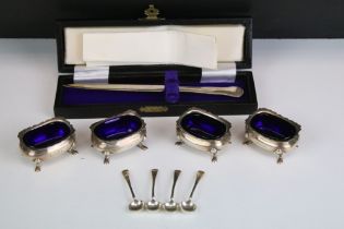 Set of four George VI silver salt cellars, with shaped upper rims and blue glass liners, each raised