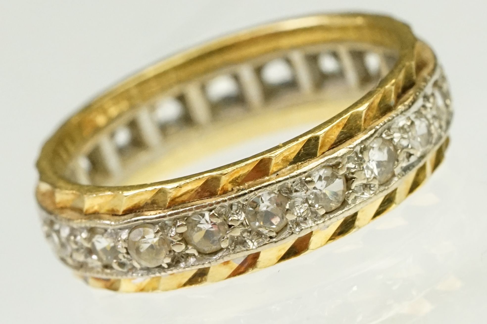 Two tone 18ct gold and white stone eternity ring. Marked 18ct to band. Size G.5.