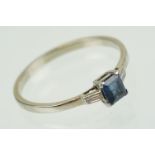 Sapphire and diamond three stone ring set with a step cut blue sapphire flanked by two baguette