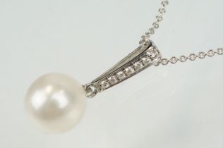 Cultured pearl and diamond pendant having a single spherical pearl with diamond accent stones to the