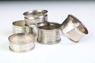 Five silver hallmarked 19th Century and later napkin rings. Four having engraved foliate detailing