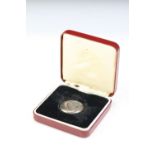 A Royal Mint 1973 Queens award to industry silver medallion within red fitted display case.