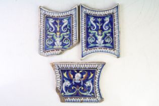 Three Continental ceramic tiles with glazed mythical style decoration on blue ground, with repeating