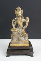 Chinese gilt metal Buddhist figure with jewelled detail, raised on a hardwood stand with four