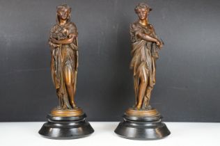 Pair of bronze effect metal sculptures of classical maidens grasping crops in their hands, raised