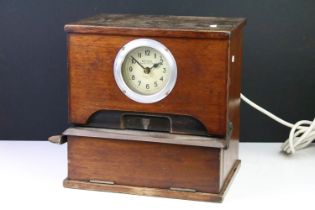 National Time Recorder Co. clocking in machine having an oak case with clock to front, with token