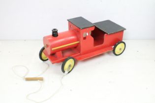 Painted wooden childs pull along wooden train, with black & red body and yellow metal wheels, approx