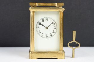 An antique 19th century brass cased carriage clock with beveled glass panels, complete with key.