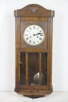 Early 20th Century oak cased pendulum wall clock having a round dial with roman numeral chapter