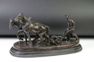 Cast bronze figure group of a farmer steering a plough drawn by two horses, raised on a stepped