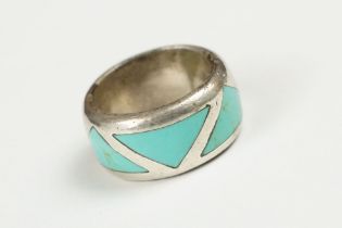 A 925 sterling silver band ring set with three flush turquoise stones of triangular form, marked 925