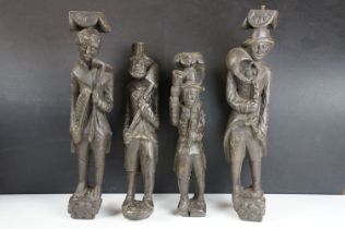 Two pairs of antique carved wooden folk art style wall mounted figures, each carrying a different