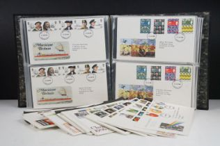 A collection of British first day covers within an album together with a selection of loose