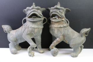 Pair of Chinese hollow cast bronze Foo Dogs / lions with mouths agape, one with its foot resting