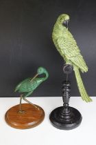 Bronze figure of a green bird, possibly a crane, raised on a circular wooden plinth (approx 22.5cm